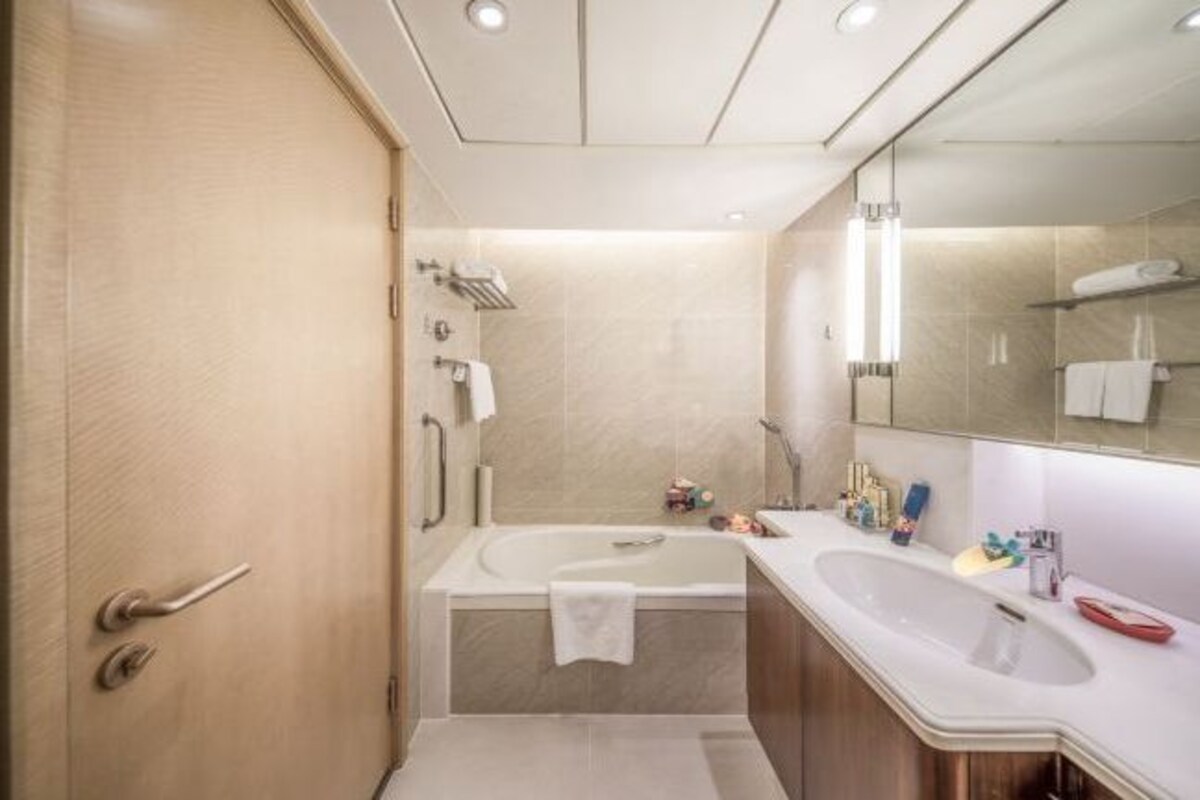 A modern bathroom with a bathtub, a sink, and a mirror.