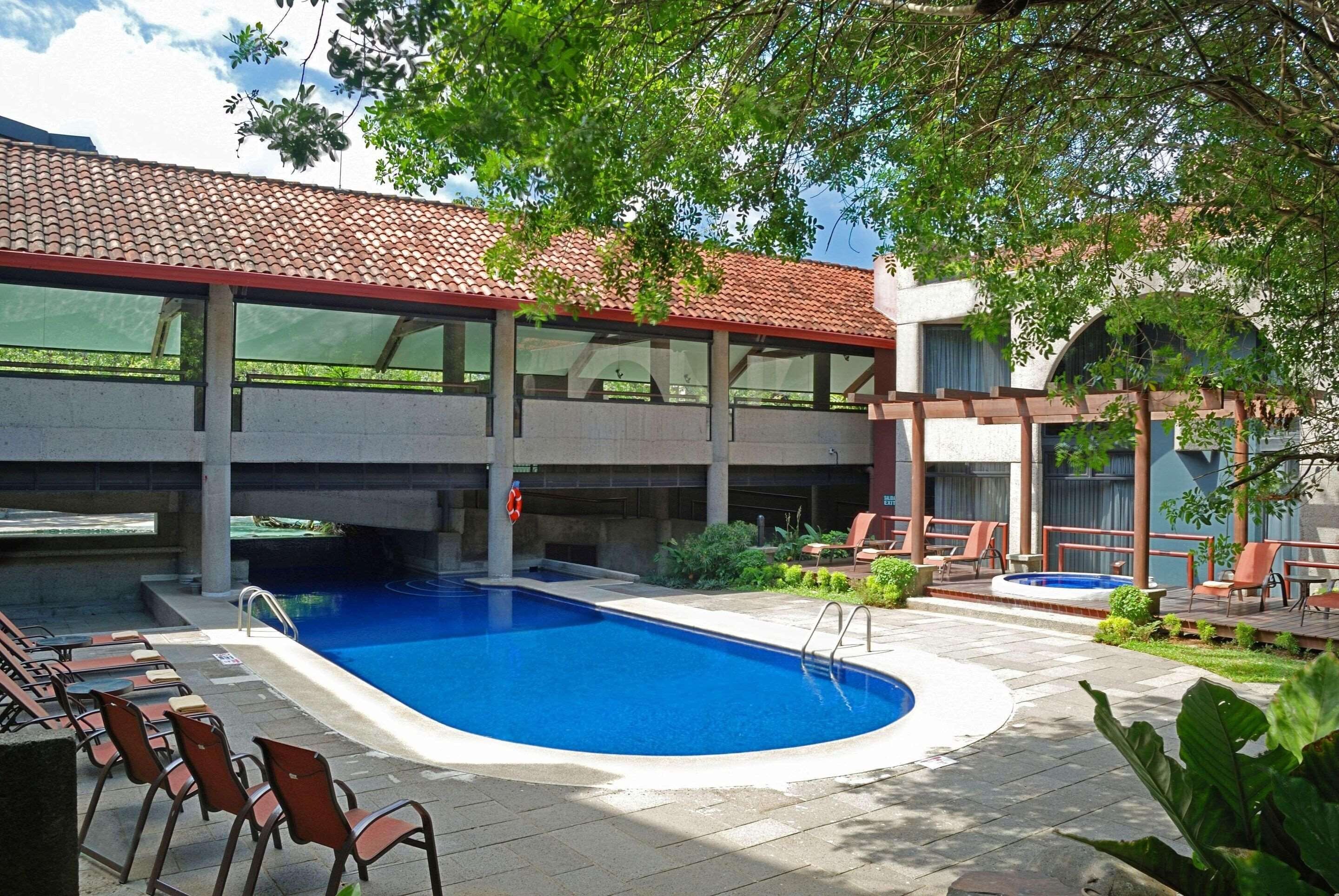 Una piscina al aire libre, sillones reclinables de piscina