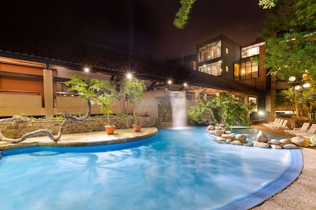 Una piscina al aire libre, sillones reclinables de piscina