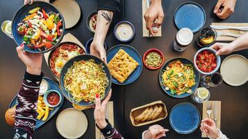 A dining table with various dishes and utensils.