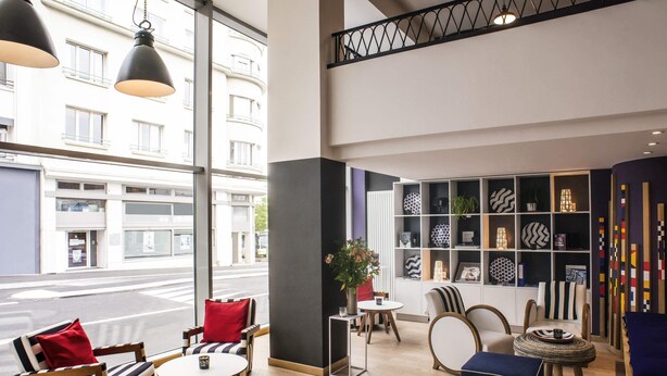 Un intérieur moderne comprenant un coin salon, une bibliothèque et une vue sur la rue.