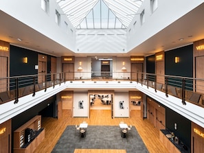 A modern hotel atrium with a glass ceiling, multiple floors, and various restaurant names like 'RENOIR' and 'CHANTILLY'. - Mercure Chantilly Resort & Conventions (Vineuil-Saint-Firmin)