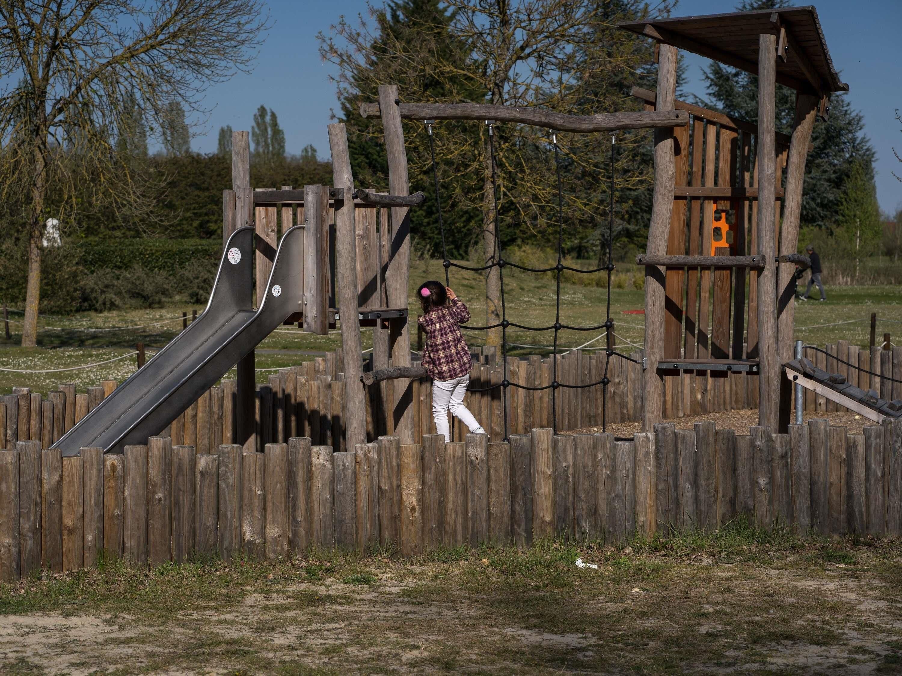 A playground with a slide and climbing structures.
