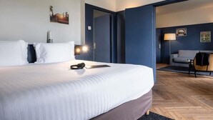 A hotel room with a large bed, a desk, a chair, and a sofa. - Mercure Chantilly Resort & Conventions (Vineuil-Saint-Firmin)