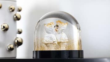 A snow globe with a figure inside, placed on a black surface.