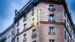 Un hotel de varios pisos con un estilo arquitectónico clásico, que cuenta con una entrada destacada con dosel y cartel.