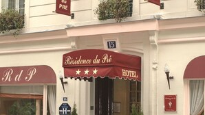 A hotel facade with signage indicating "Residence du Pré" and "Hotel." There are three stars on the awning, a number "15" above the entrance, and a "HOTEL" sign on the right. - Résidence du Pré (Paris)