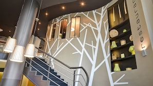 Ein modernes Interieur mit einer Treppe, Wandregalen mit Dekorationsobjekten und einem Schild mit der Aufschrift 'restaurant'.