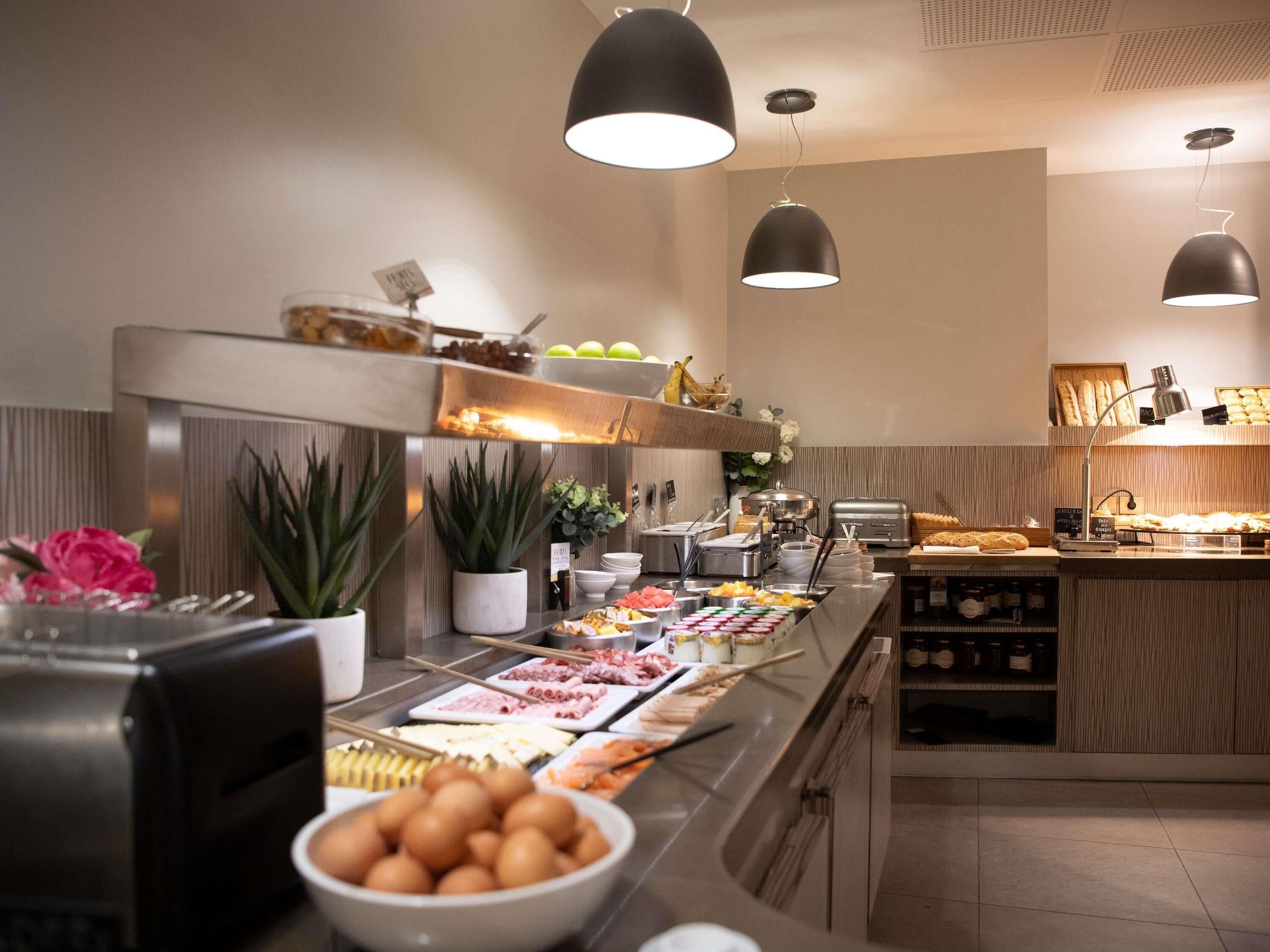 Een buffetopstelling met diverse gerechten, een koffieapparaat en een koelkast.