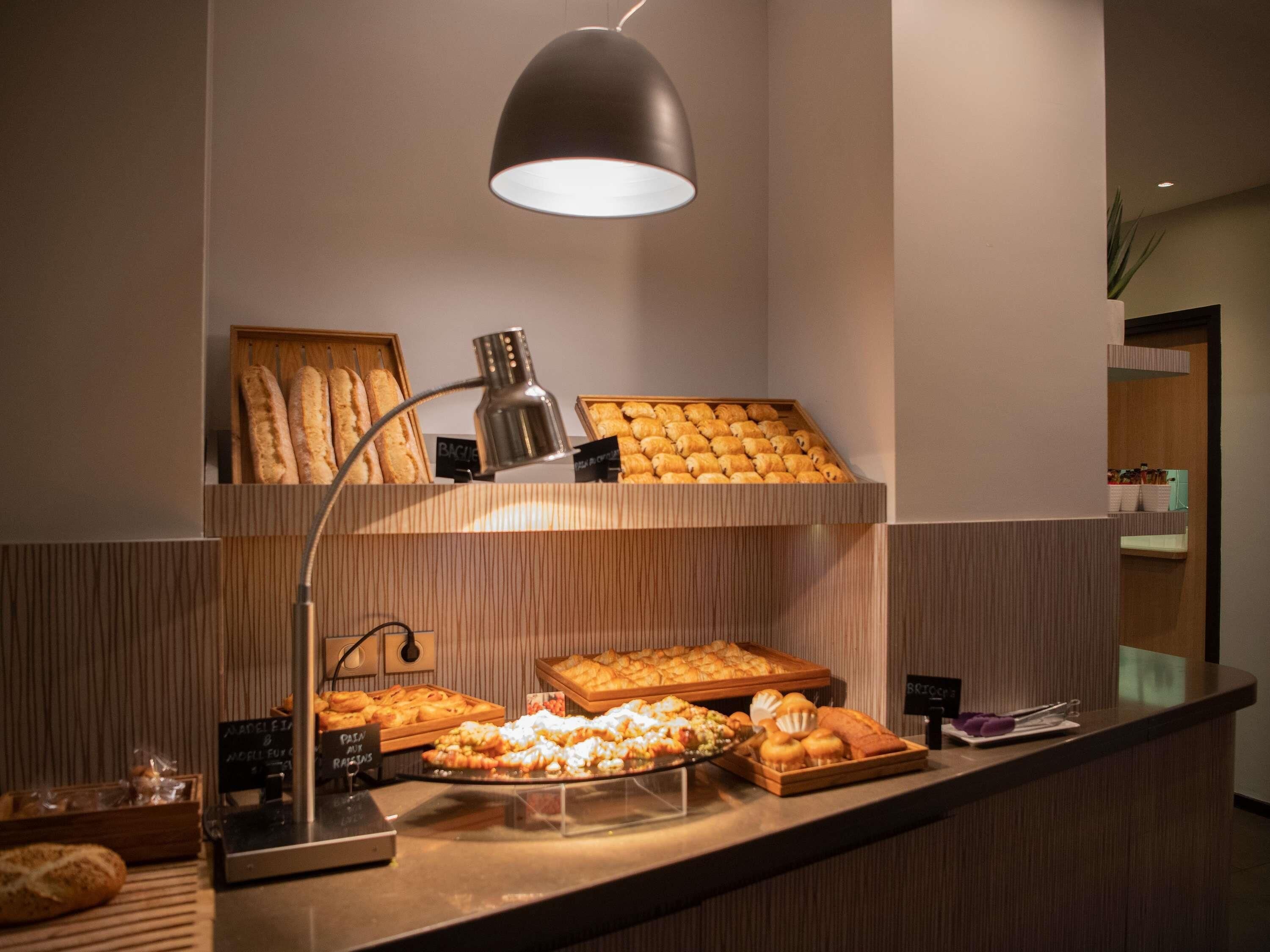 Una vetrina di pasticceria con diversi prodotti da forno e una macchina per il caffè.