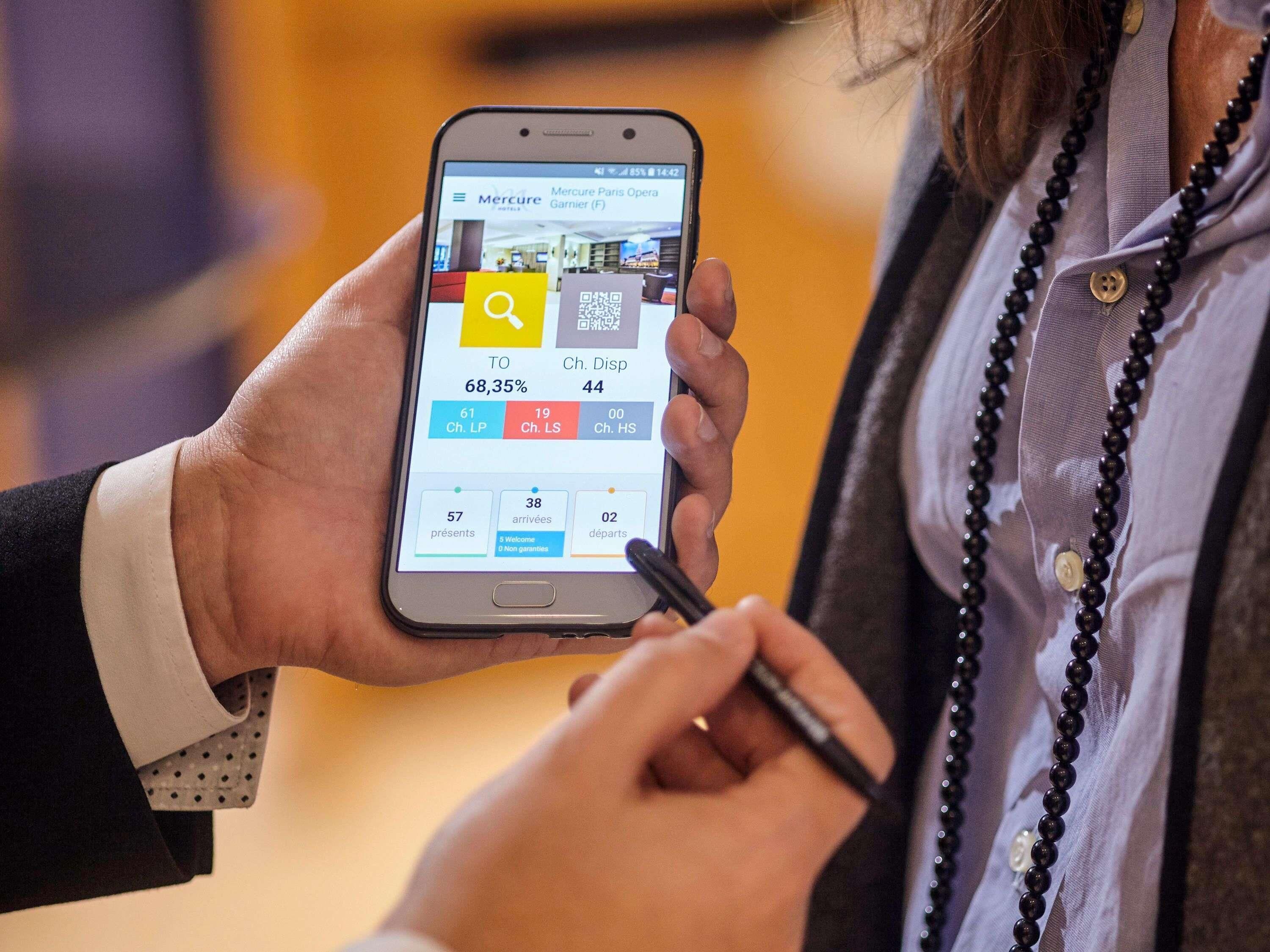 Eine Person hält ein Smartphone, das eine Buchungsansicht für ein Hotel zeigt.