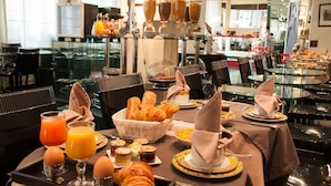 A breakfast buffet with various food items and beverages. - Hotel Ile de France Opéra (Paris)