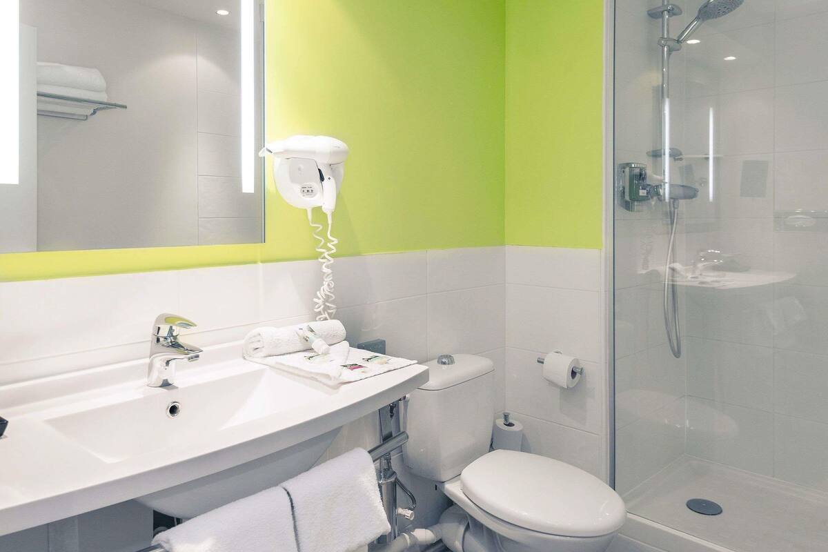 A bathroom with a sink, toilet, and shower.