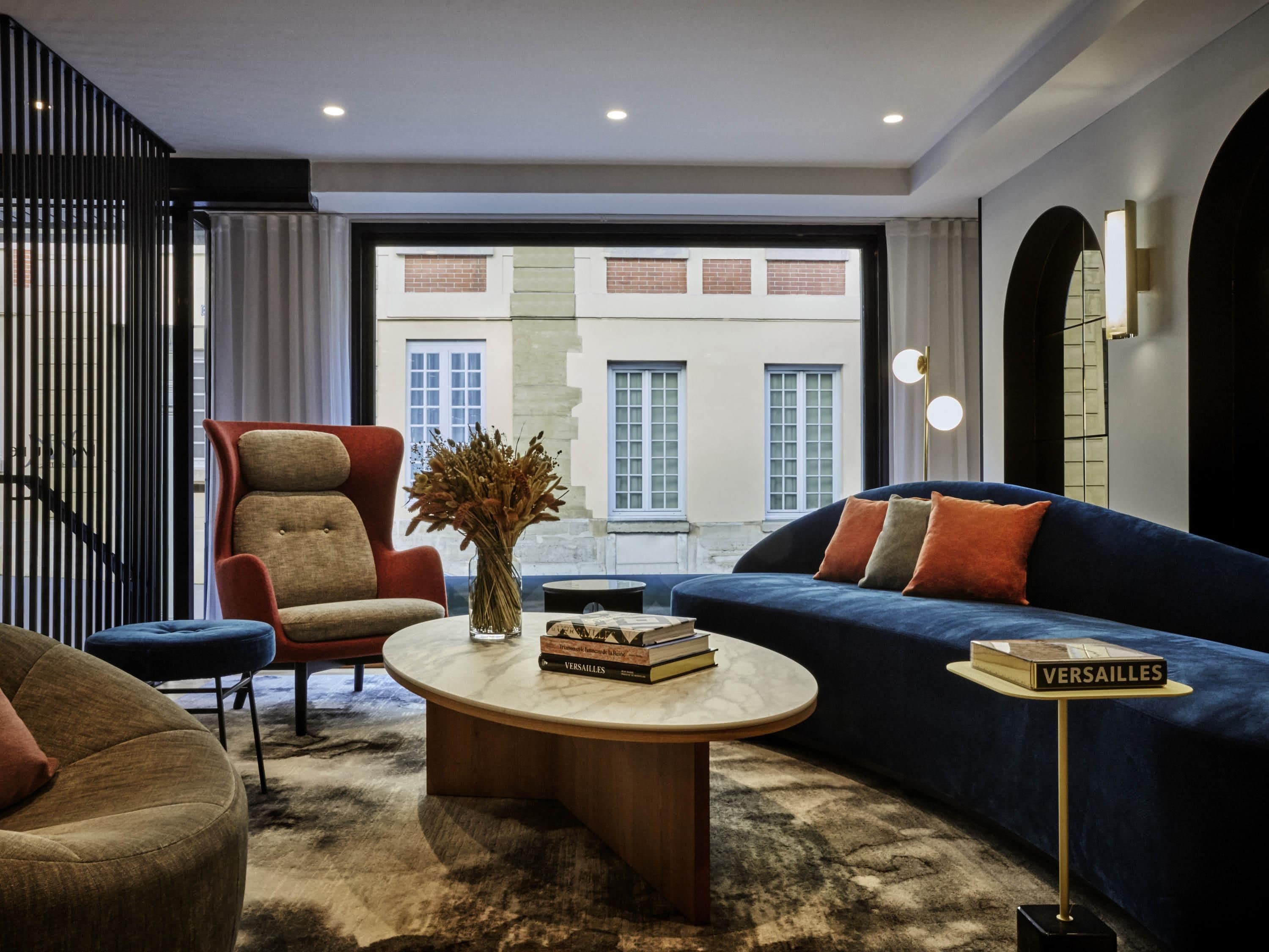 Una sala de estar moderna con sofá, sillón, mesa de centro y estantería.