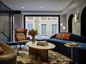 Una sala de estar moderna con sofá, sillón, mesa de centro y estantería.