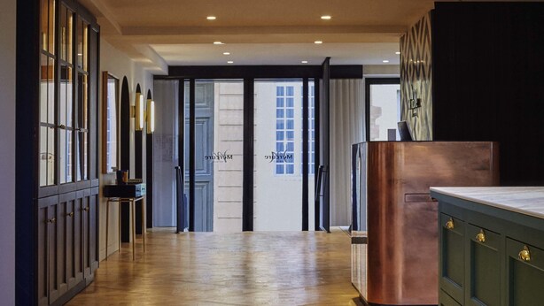A modern kitchen with wooden flooring, a copper refrigerator, and a view through the glass doors. - Mercure Versailles Chateau (Versailles)