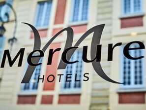 A hotel sign with the name 'Mercure Hotels' in a stylized font. - Mercure Versailles Chateau (Versailles)