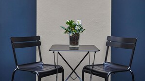 A small table with two chairs and a potted plant in the center. - Mercure Versailles Chateau (Versailles)