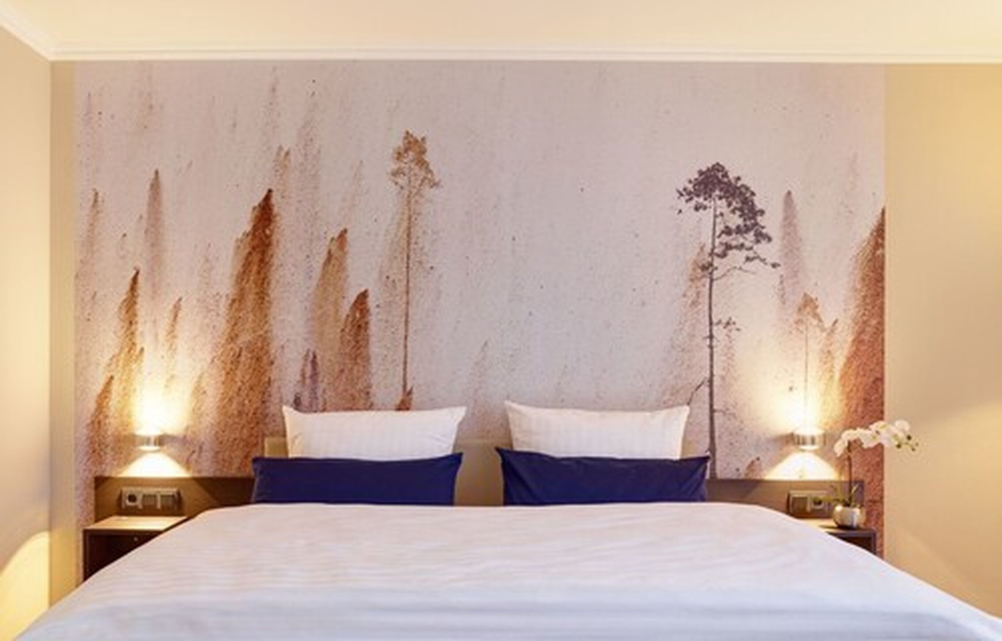 Ein Hotelzimmer mit einem großen Bett, zwei Nachttischen und einer strukturierten Wand.