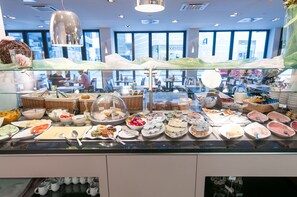 A buffet with various food items and utensils. - Aquis Grana City Hotel (Aachen)