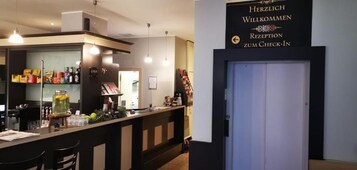 Un'area di accoglienza con una scrivania per il check-in, una segnaletica che indica la reception e una porta.