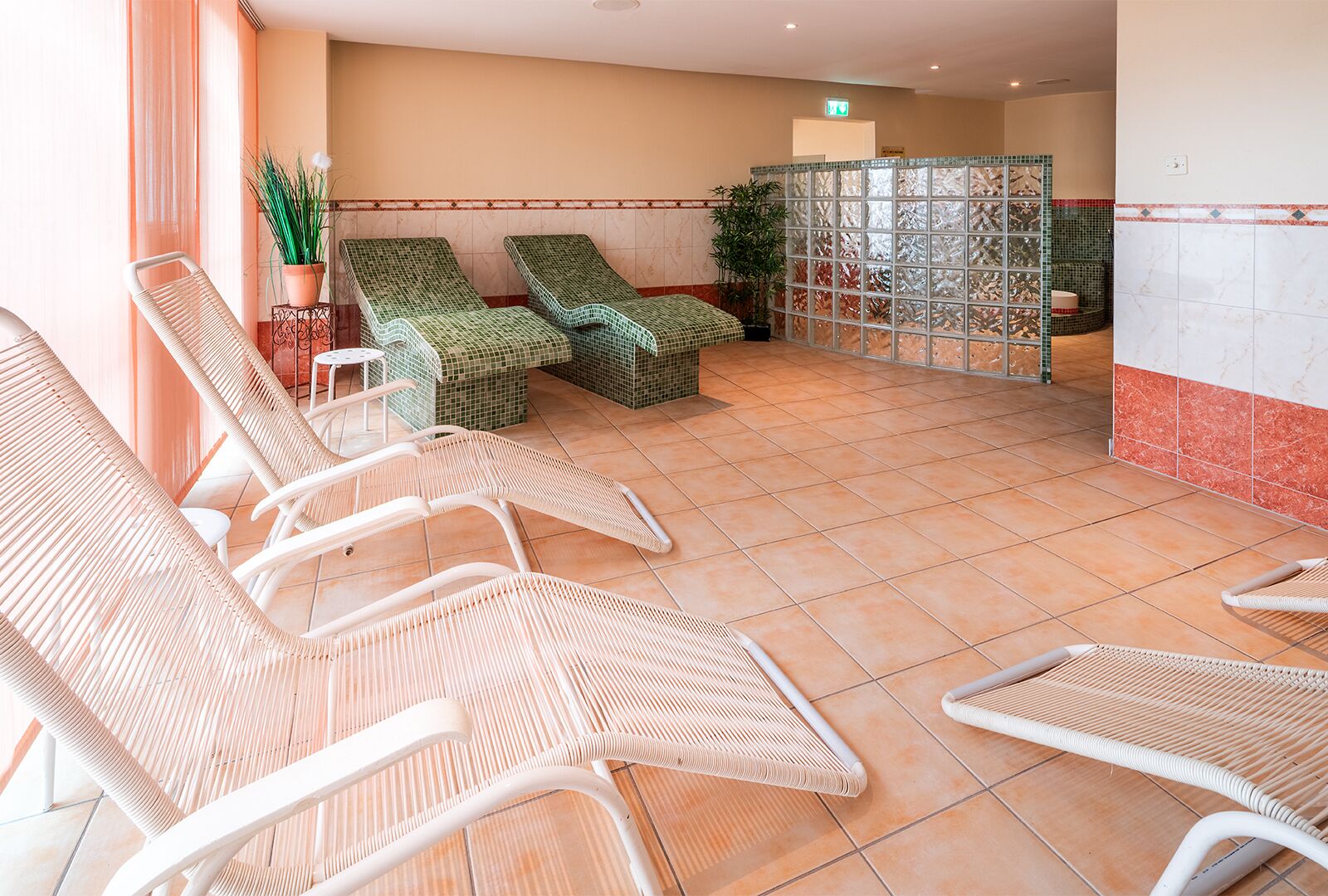 Un espace spa doté de chaises longues et d’un sol carrelé.