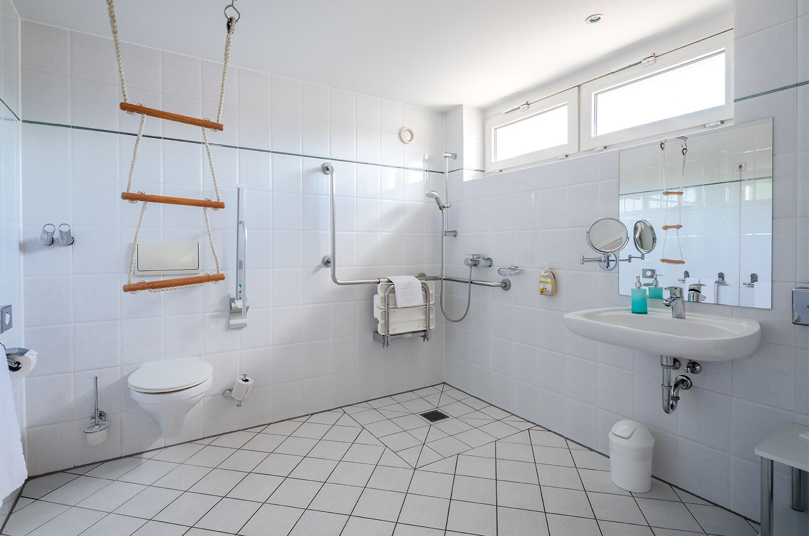 Un baño moderno con cabina de ducha de vidrio, un lavabo blanco y un inodoro.