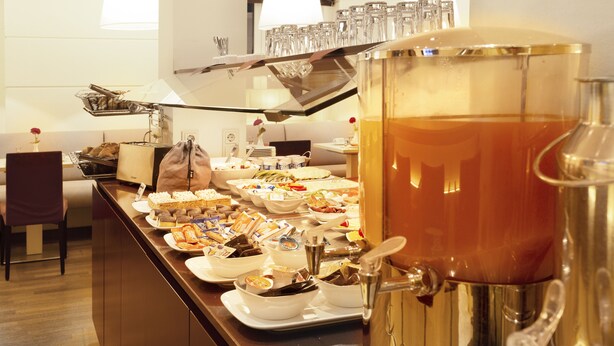 Un buffet proposant divers plats et un grand distributeur de boissons.