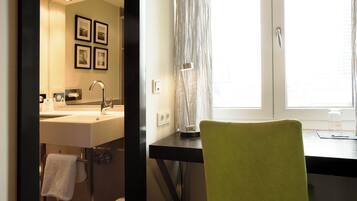 A bathroom with a sink, mirror, and a towel rack.