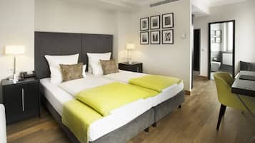 Una habitación de hotel moderna con una cama grande, mesitas de noche, un escritorio y una silla.