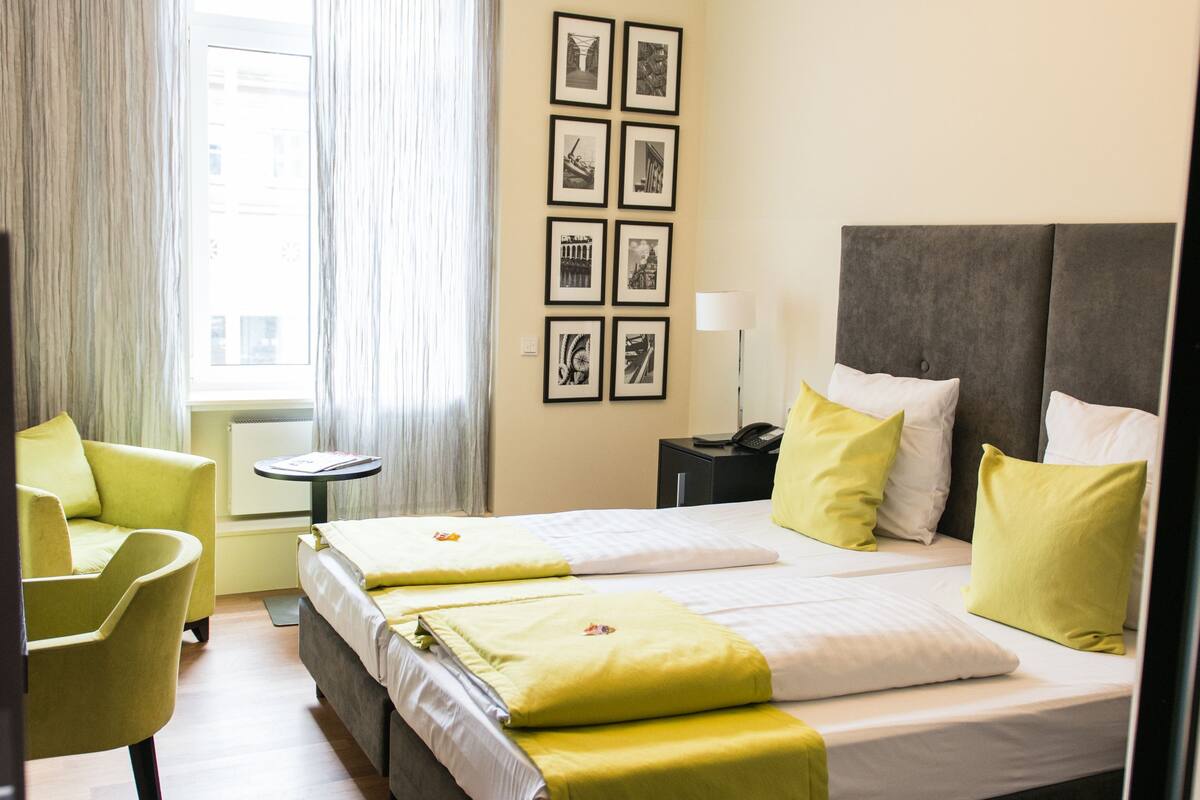 Quarto de hotel com uma cama grande, uma escrivaninha e uma cadeira.