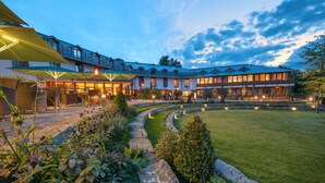A hotel with a courtyard, outdoor seating area, and a well-maintained lawn.