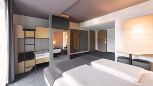 Een moderne hotelkamer met een groot bed, een bureau, een stoel, een kledingkast en een spiegel.