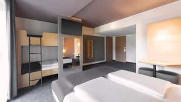 Una habitación de hotel moderna con una cama grande, un escritorio, una silla, un armario y un espejo.