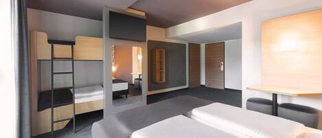 A modern hotel room with a large bed, a desk, a chair, a wardrobe, and a mirror.