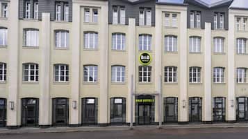 A multi-story hotel building with a symmetrical facade, featuring a central entrance with a sign for B&B Hotels.