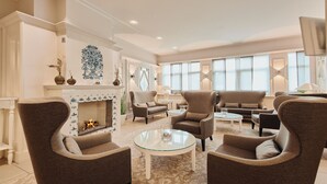 Una sala de estar amplia con chimenea, asientos cómodos y ventanas grandes.