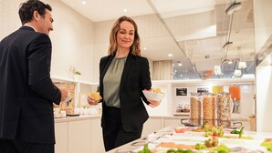 Montaje de bufé con diversos alimentos y una persona sirviendo.
