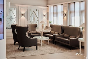 A modern living room with a sofa set, armchairs, a coffee table, and decorative lighting.