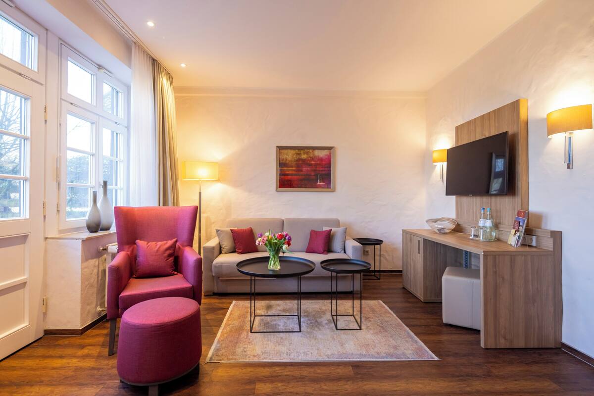 A modern living room with a sofa, armchair, coffee table, and TV.