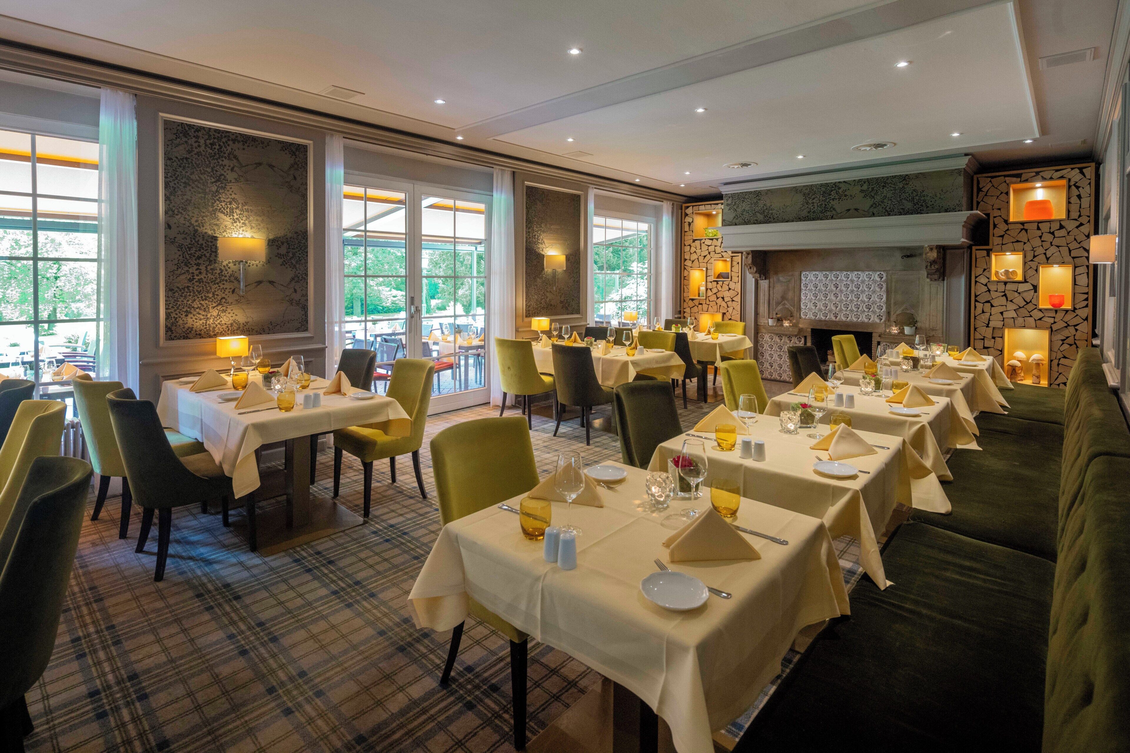 A restaurant with multiple tables, chairs, and a fireplace.