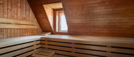 A wooden interior with a sloped ceiling and a small window.