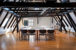 Ein Konferenzraum mit Holzboden, einem langen Tisch und Stühlen.