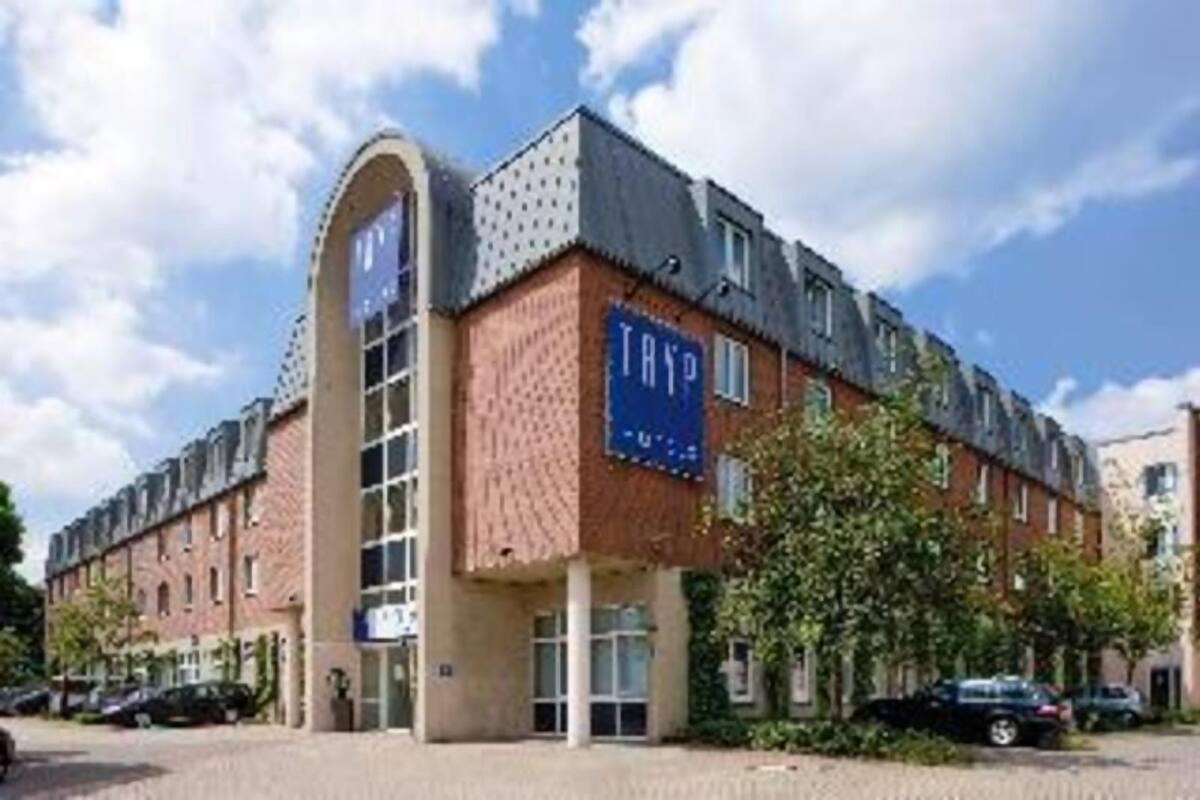 Un edificio con un llamativo letrero que dice 'TRIP', una gran entrada en arco y fachada de ladrillo.