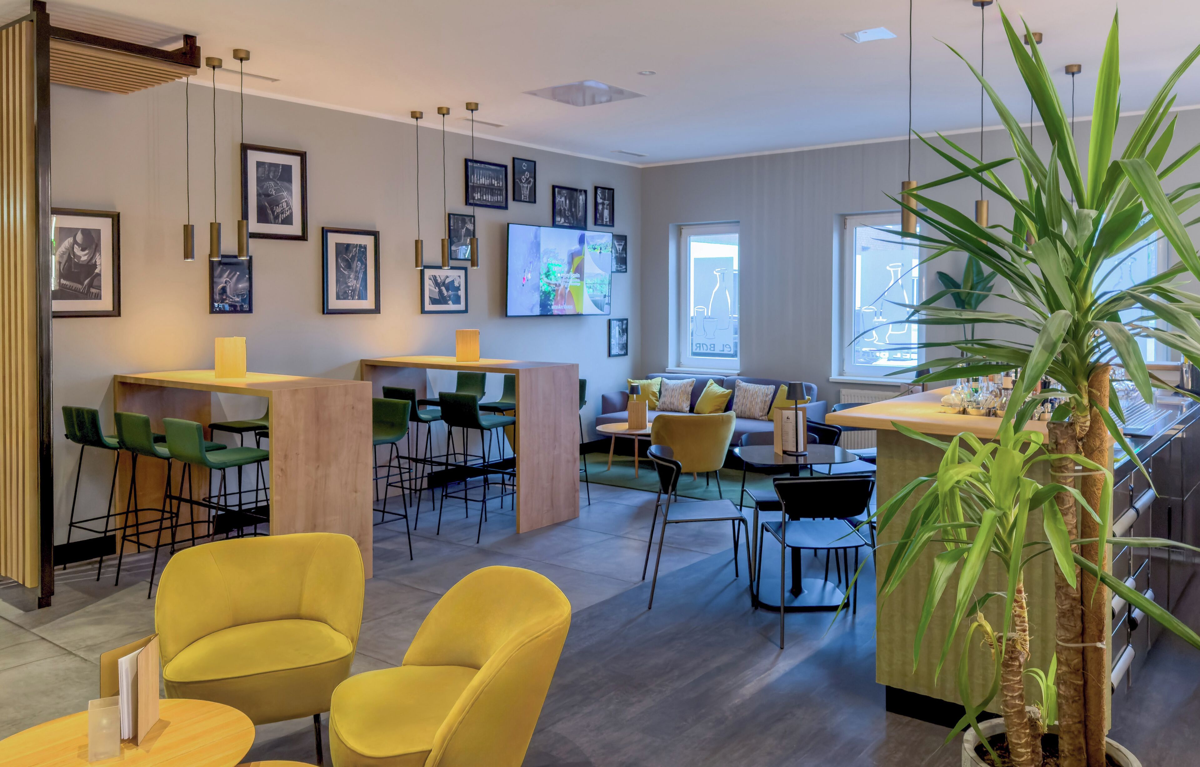 A modern interior with a bar area, seating, and artwork on the walls.