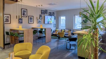 A modern interior with a bar area, seating, and artwork on the walls.