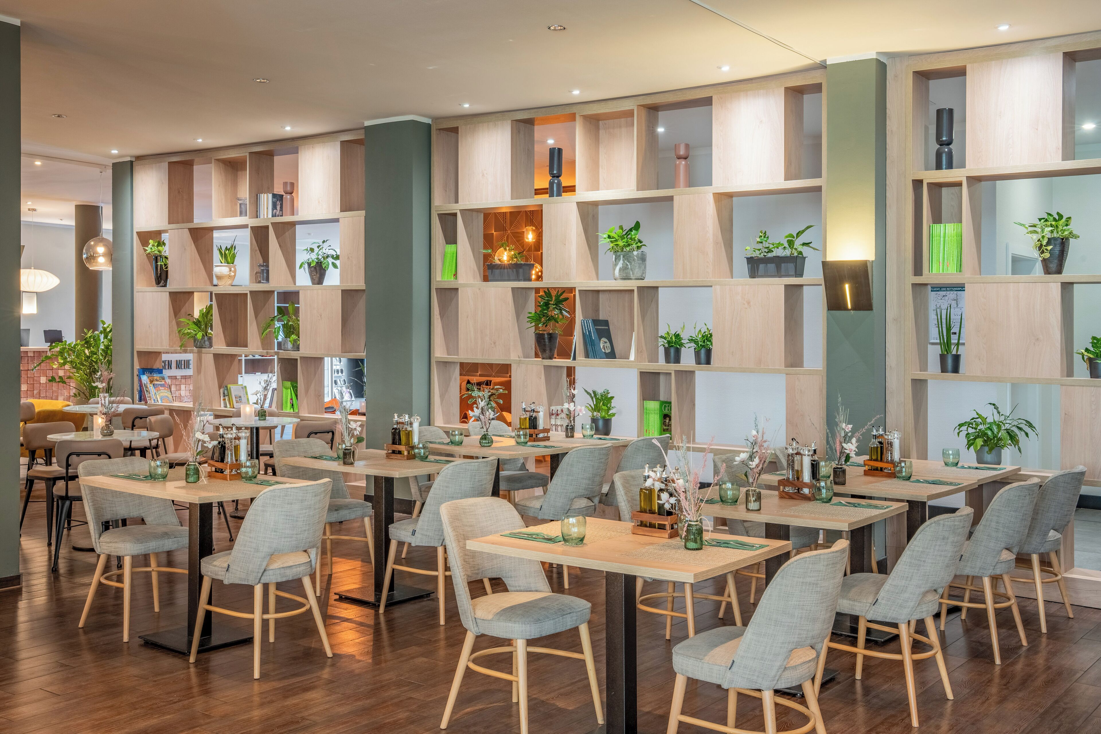 Un restaurant moderne avec des étagères, des tables et des chaises en bois.