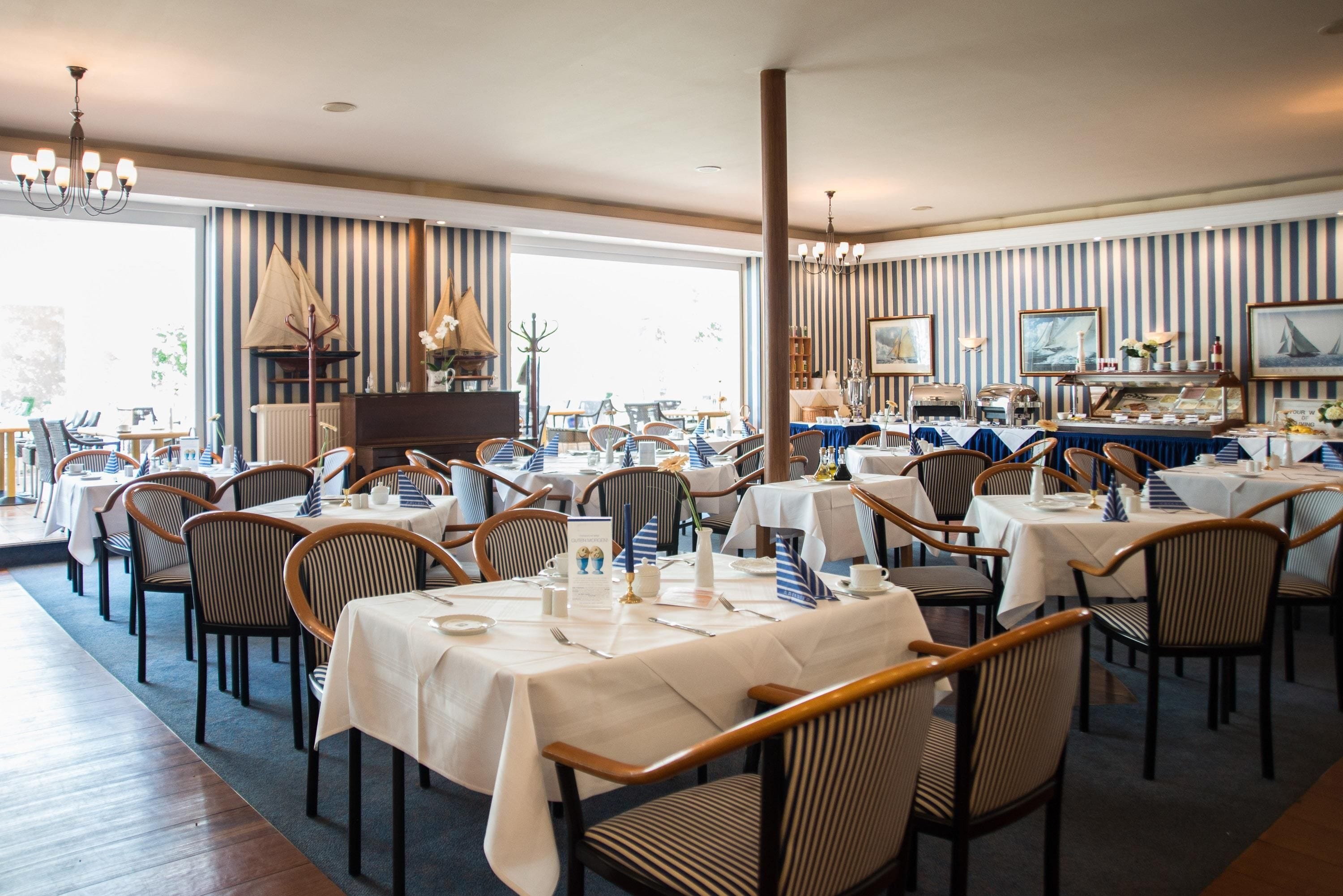 Un ristorante con pareti a righe, diversi tavoli e sedie.