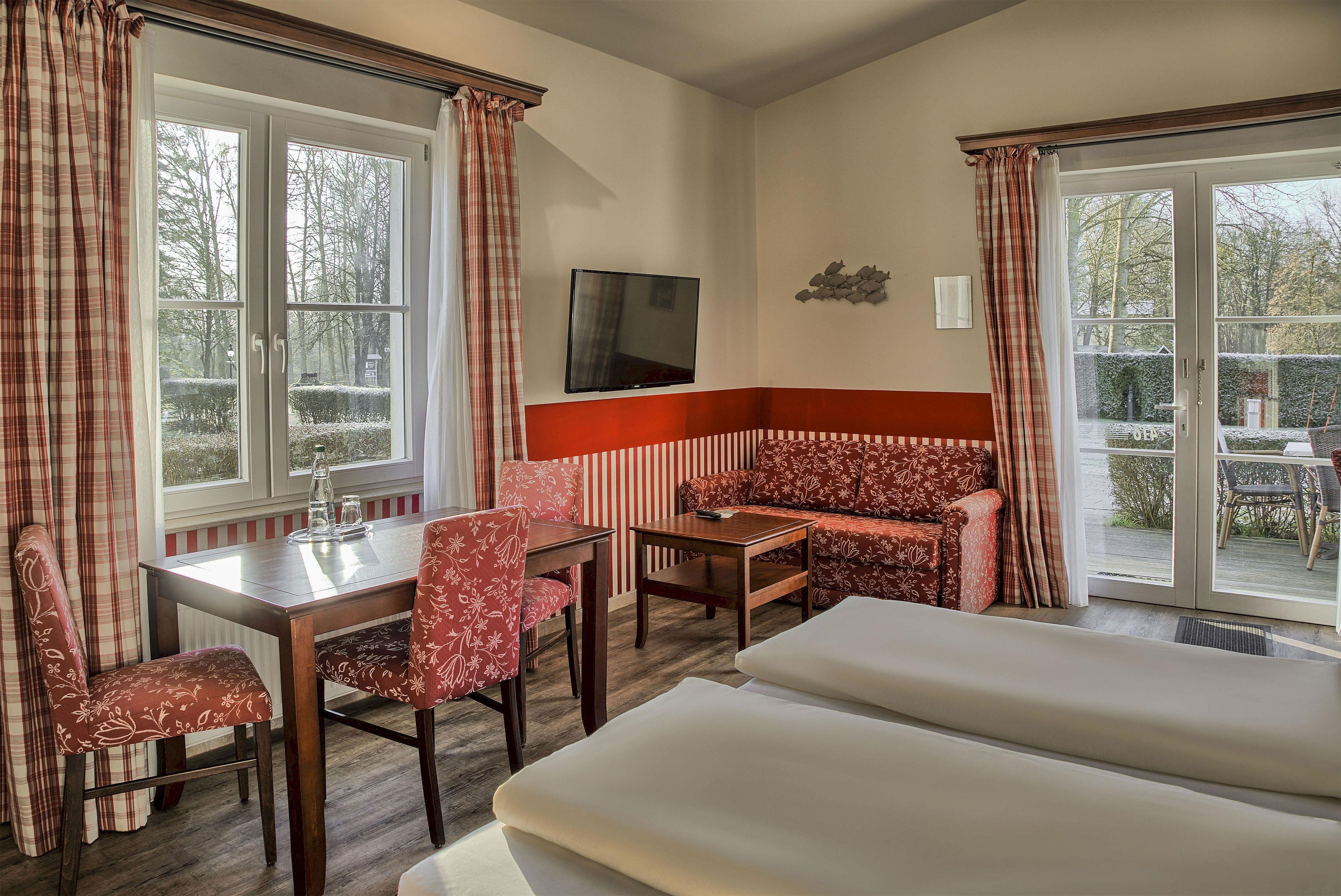 Une chambre d’hôtel avec un canapé, une table, un téléviseur et une vue sur l’extérieur.