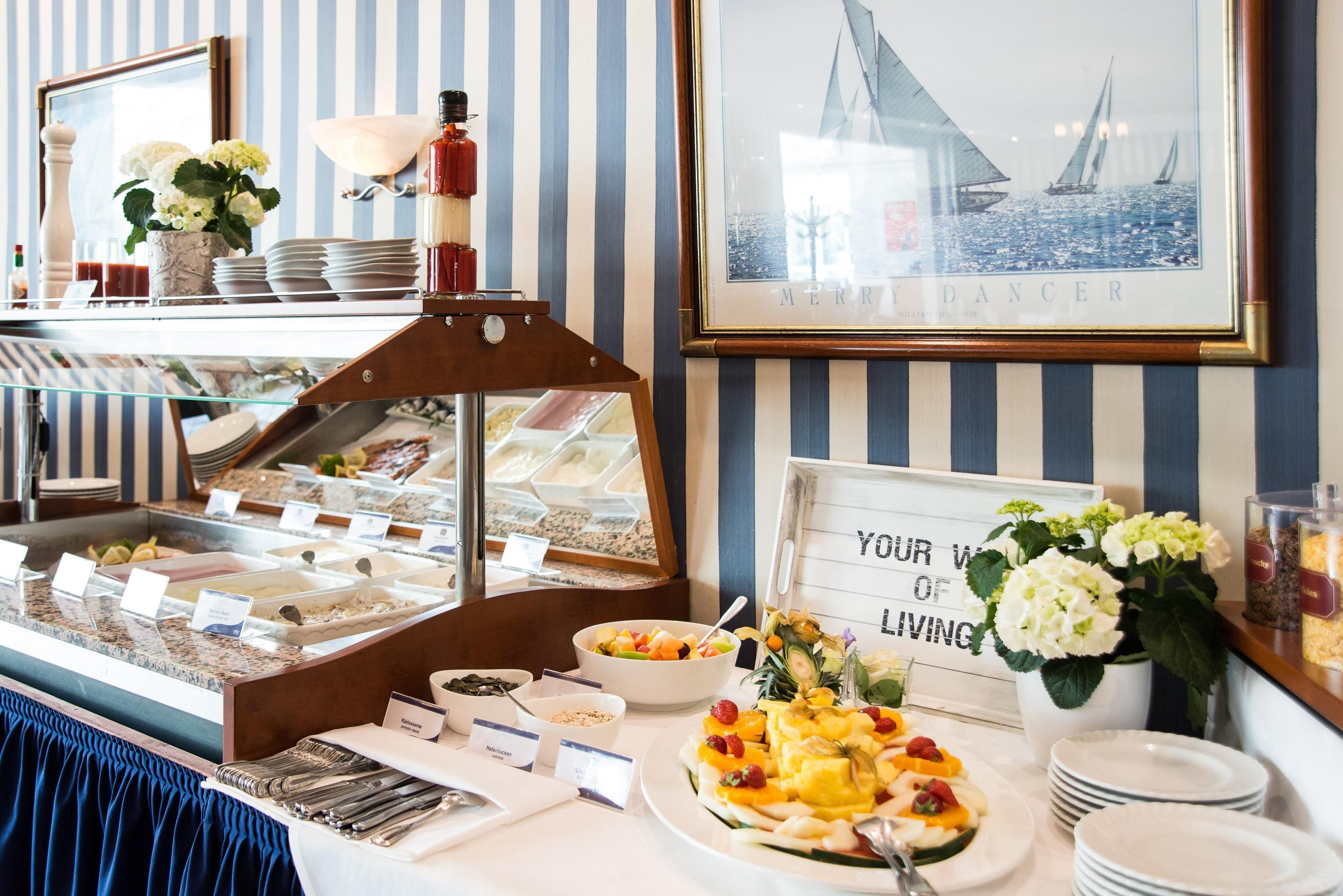 A buffet setup with various food items and a sign that reads 'YOUR WORLD OF LIVING'.